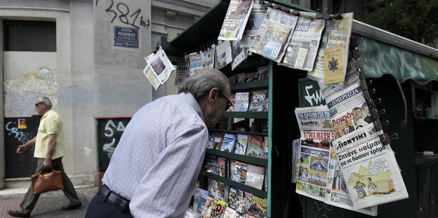 Ein Mann an einem Kiosk mit Zeitungen