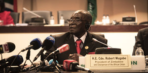 Simbabwes Präsident Mugabe sitzt hinter Mikrofonen auf dem AU-Gipfel