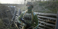 Soldat in Tarnkleidung steht im Wald
