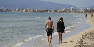 Ein Mann und eine Frau gehen am Strand spazieren