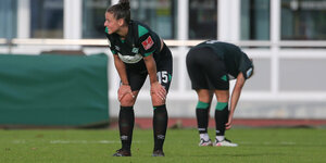Zwei Spielerinnen von Werder Bremen stützen sich erschöpft auf die Knie