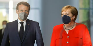 Emmanuel macron und Angela Merkel gehen nebeneinander mit Mundschutz