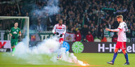 Rauch von einem Böller auf dem Fußballrasen während des Spiels
