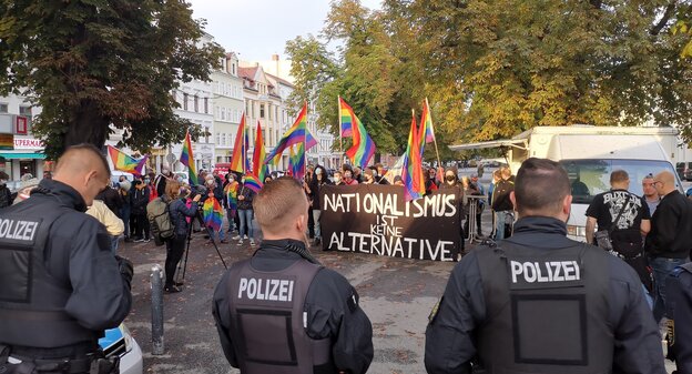 Eine Anti-AfD-Demo steht vor ein paar Polizist*innen