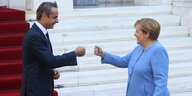 Angela Merkel und Griechenlands Regierungschef Mitsotakis begrüßen sich mit freundlichem Faustschlag