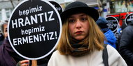 eine junge Frau mit Hut trägt ein Schild: "Wir sind alle Hrant, wir sind alle Armenier"