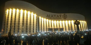 Protestierende erleuchte ihre Smartphones vor einem beleuchteten Gebäude
