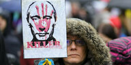 Eine Demonstratin mit einem Anti-Putin-Plakat