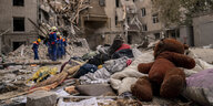 Ein Teddybär liegt auf einem Schutthaufen vor einem zerstörten Haus in Charkiw