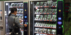 Frau vor einem Cannabis-Automaten