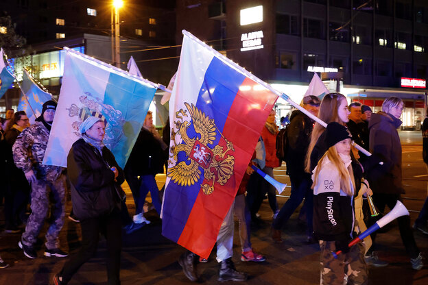 Demonstrierende halten beim so genannten „Montagsspaziergang“ in Chemnitz Russlandfahnen hoch