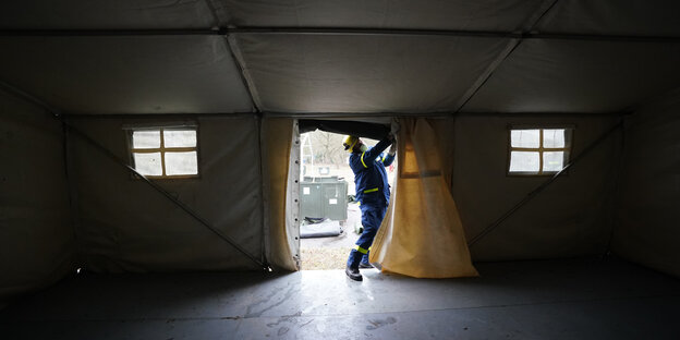 Ein Mitarbeiter des Technischen Hilfswerks baut ein Zelt an der Schnackenburgallee auf