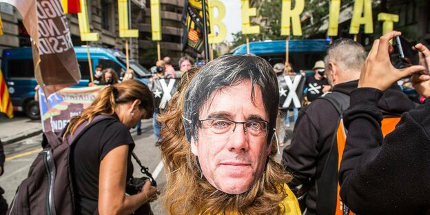 Eine Demonstrantin mit der Maske von Carles Puigdemont