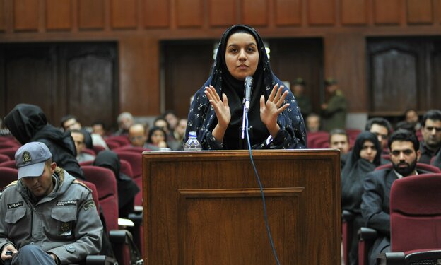 Reyhaneh Jabbari vor einem Mikrofon in einem Gerichstssaal