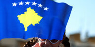 Ein Kind mit der Fahne des Kosovo