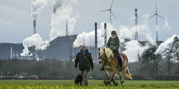 Mann und Reiterin mitr Pferd vor BP-Raffinerie in Gelsenkirchen