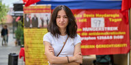 Eda Deniz Haydaroglu steht mit verschränkten Armen vor ihrem Protestzelt