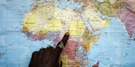 Ein Finger zeigt auf einer Landkarte den Ort El Geneina im Sudan
