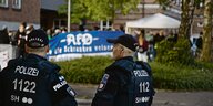 Zwei PolizistInnen stehen vor der linken Demo am Kieler Gerichtsgebäude