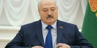 Ein Mann, es ist Alexander Lukaschenko, in selbstgefälliger Pose