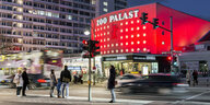 Das Kino Zoopalast in Berlin. Das gebäude ist rot angeleuchtet. Es ist dunkel.