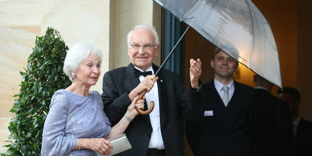 Stoiber in Begelitung seiner Frau mit Regenschirm.