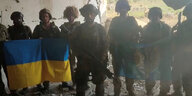 Ukrainische Soldsten posieren mit ihrer Landesflagge