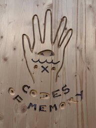 Eine mit Symbolen verzierte Hand und der Schriftzug "Codes of Memory"