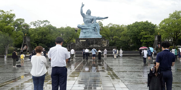 Menschen beten vor einer Statue