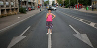 Eine Person steht auf einer leeren Straße