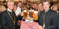 Markus Söder im Bierzelt mit netten Menschen beim Biertrinken