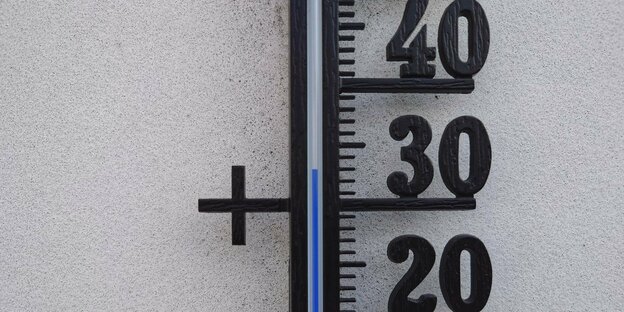Thermometer an einer Hauswand.