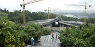 Bauarbeiten am zweiten Teil des Nationalmuseum Holodomor, drei Baukräne stehen neben dem Rohbau im Hintergrund der Fluss und die Stadt