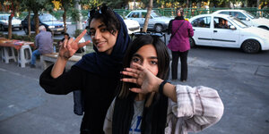 Zwei iranische Frauen posieren für ein Foto, ohne Kopftuch, das ihre Haare bedeckt.