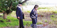 Eine Frau in einem traditionelle Kostüm und ein alter Mann mit langem Bart auf einem Spaziergang