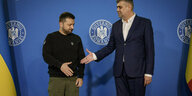 Präsident Selenski und Premierminister Ciolacu geben sich die Hände.