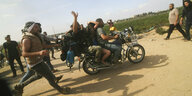Palästinenser transportieren eine gefangene israelische Zivilistin (Mitte) aus dem Kibbuz Kfar Azza in den Gazastreifen auf einem Motorrad, Männer rennen neben dem Motorrad