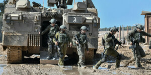 Israelische Soldaten verlassen ein gepanzertes Fahrzeug auf einer schlammigen Straße