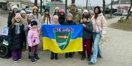Eine Gruppe Kinder und Jugendlicher mit einer ukrainischen Flagge