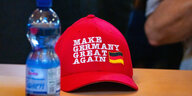 "Make Germany great again" steht auf einer Kappe, die beim Landesparteitag der schleswig-holsteinischen AfD auf einem Tisch liegt. Daneben steht eine Wasserflasche.