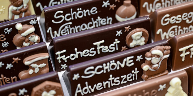 Auf Schokoladentafeln sind mit Zuckerguss Sprüche wie "Schöne Weihnachten" oder "Frohes Fest" geschrieben