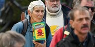 Eine Frau hält einne Packung mit dem Unkrautvernichtungmittel Roundup in den Händen