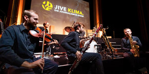 Musiker spielen auf der Bühne der Journalismus-Show Jive Klima