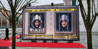 Plakaten mit Porträts von Alice Weidel und Tino Chrupalla hinter Gitter hinter Gittern. Die Instalation steht vor dem Kanzleramt, vor einem roten Teppich