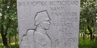 Reliefdatrstellung eines Soldaten aus dem frühen 20. Jahrhundert, dazu eingemeißelter Text: "Das mächtige Deutschland nahm Finnlands junge Mäner auf und erzog sie"