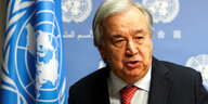 UN-Generalsekretär Guterres steht vor der Flagge der Vereinten Nationen