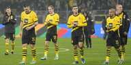 Die Spieler von Borussia Dortmund schleichen traurig dreinblickend vom Platz