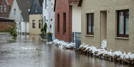 Häuserreihe an einer Straße, die unter Wasser steht