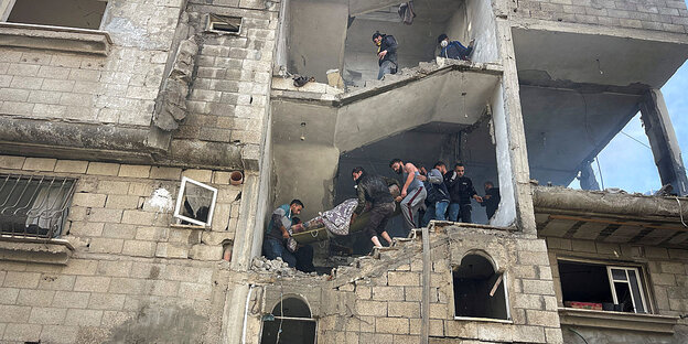 Palästinenser tragen die Leiche einer Frau aus einem zerstörten Haus in Gaza.