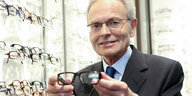 Günther Fielmann mit einer seiner Brille in der Hand